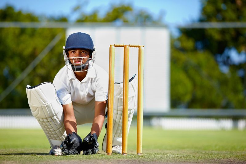 a young cricket player on a cricket field