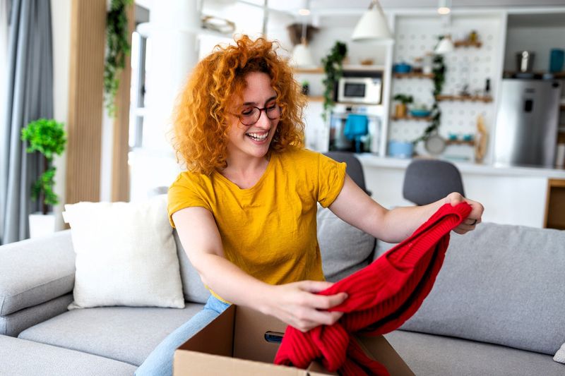 a female unboxing an old red dance dress