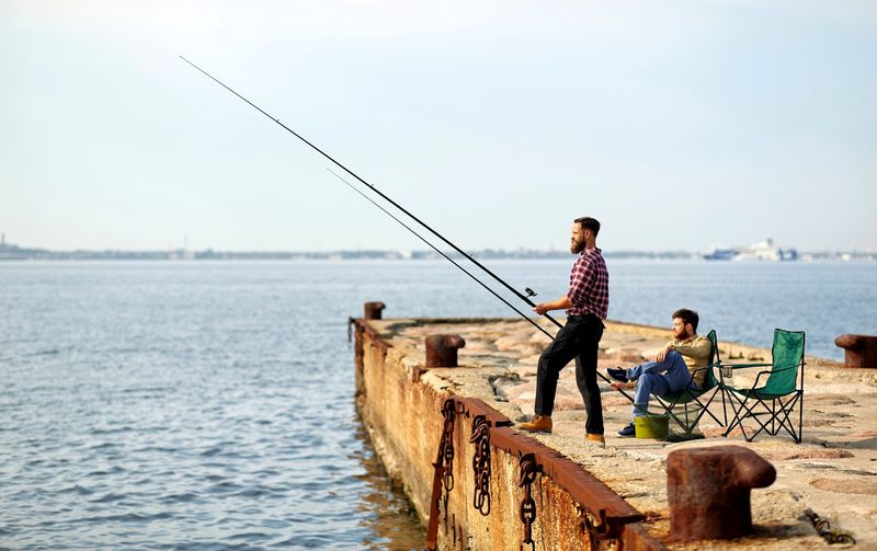 a man fishing from a pier into the ocean