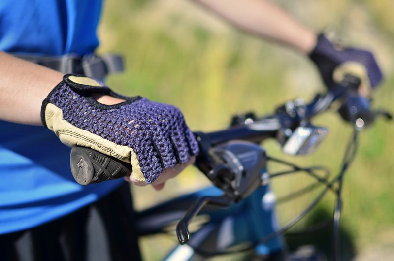 a cyclist holding the handlebars wearing cycling gloves