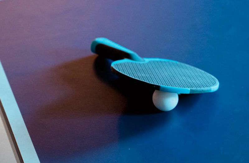 a ping pong paddle resting on top of a ping pong ball