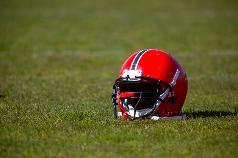 a red football helmet placed on green grass