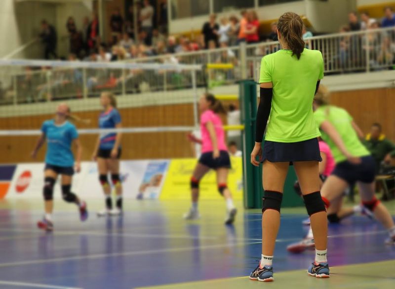 a volleyball game on a blue volleyball court