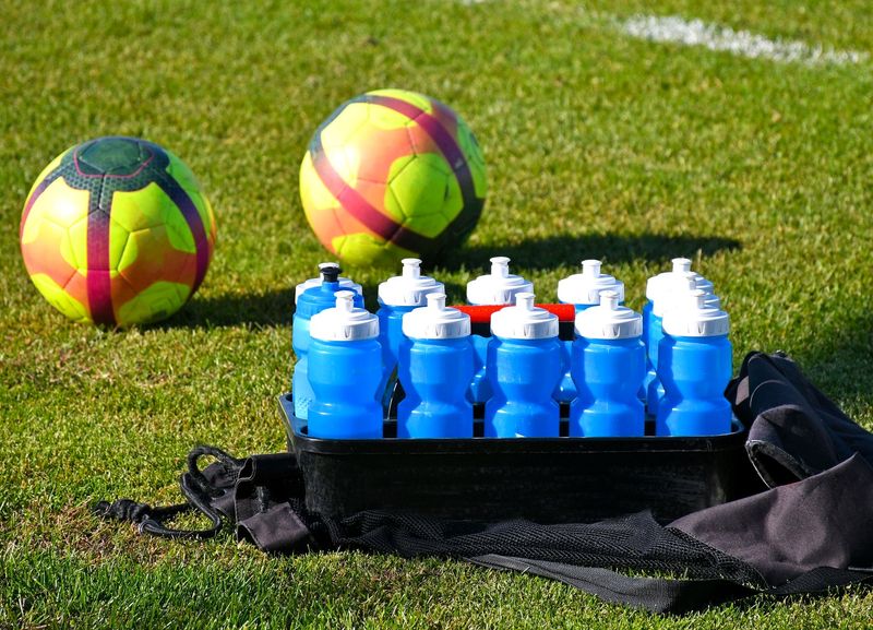 soccer team water bottles and soccer balls on a pitch