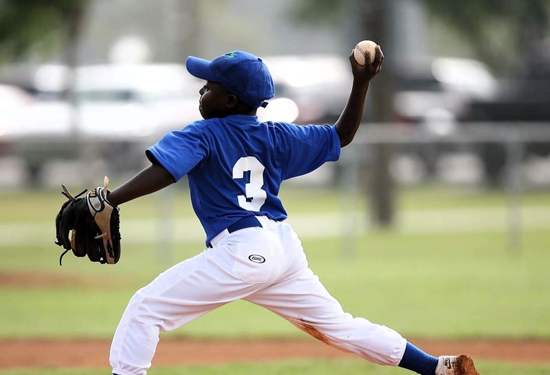 a youth baseball player pitching a baseball