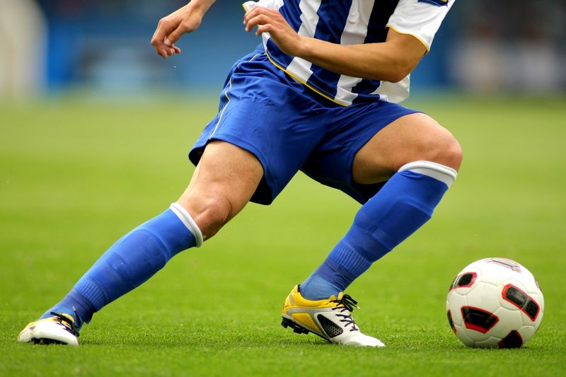 a soccer player dribbling a soccer ball