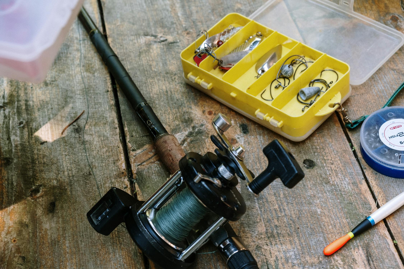a fishing rod and tackle box on a wooden table