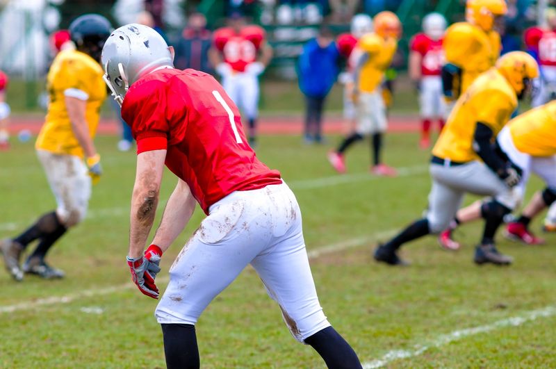 a football player wearing a red and white uniform standing on a line during a football game