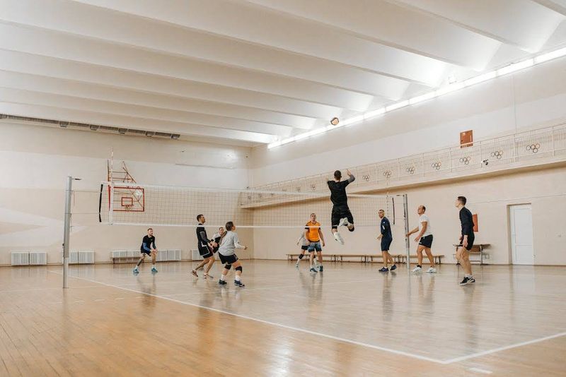 A man hitting a volleyball over the net