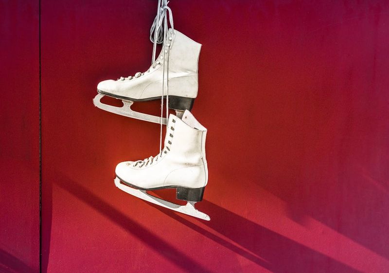 white ice skates against a red background