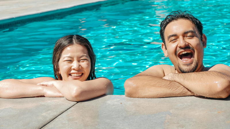 a woman and a man in a swimming pool smiling