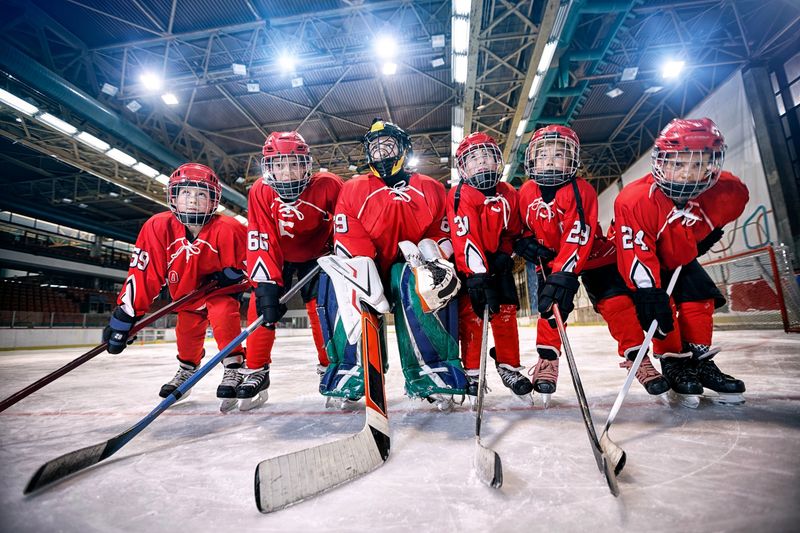 a youth hockey team on the ice with the goalie in the center