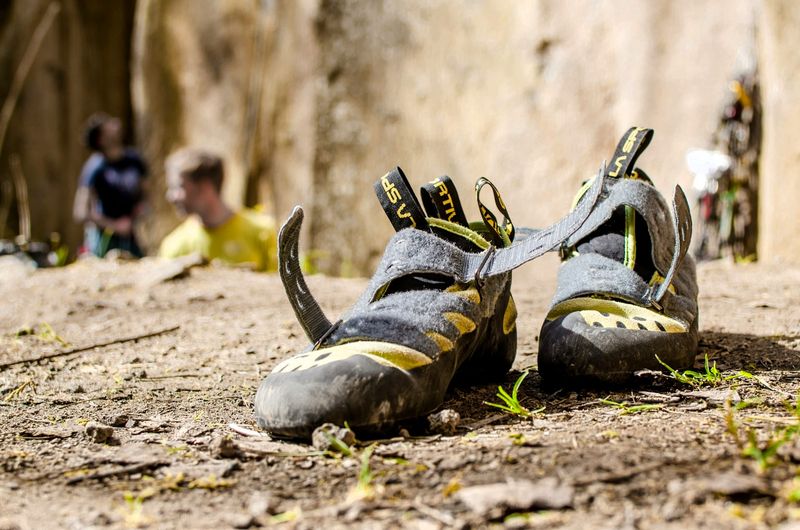 a pair of used climbing shoes sitting on a rock