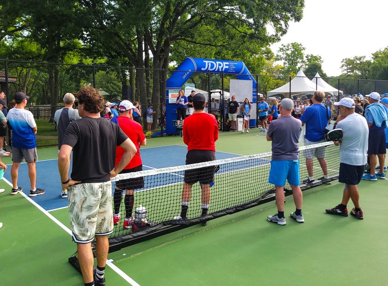 a pickleball tournament crowd listening to a tournament host