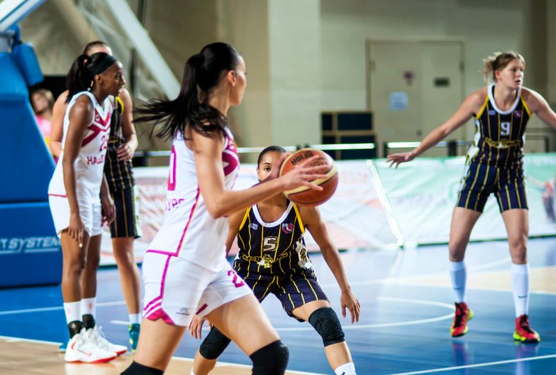 an adult female basketball player bouncing the basketball during a game