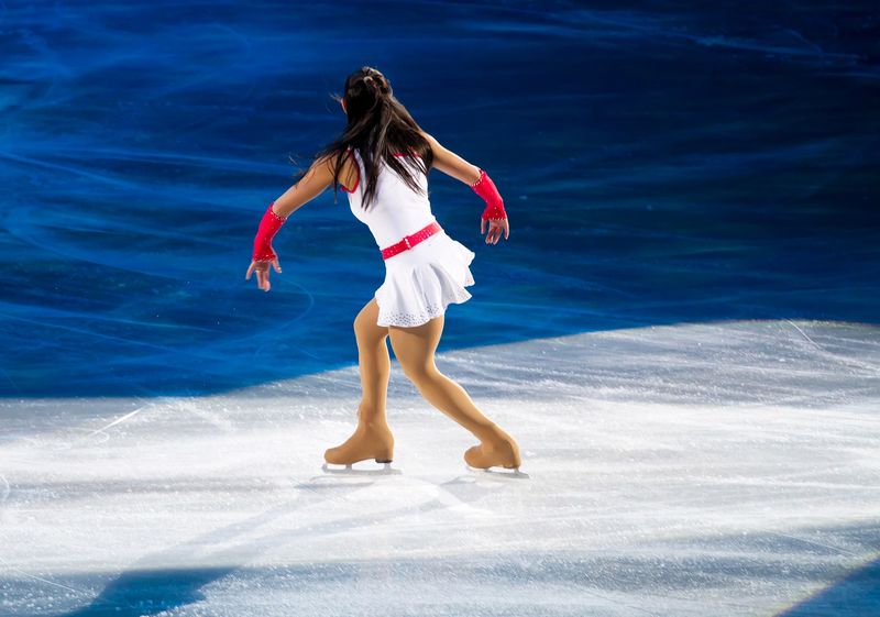 a female figure skating performing a routine on ice