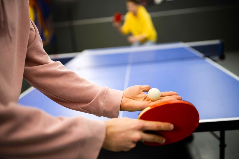 a ping pong player about to serve a ping pong to an opponent