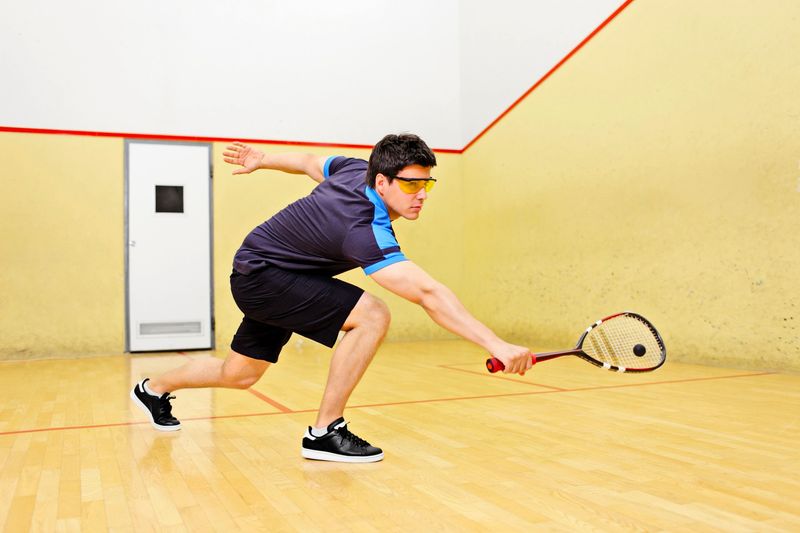 a man stretching to hit a squash ball