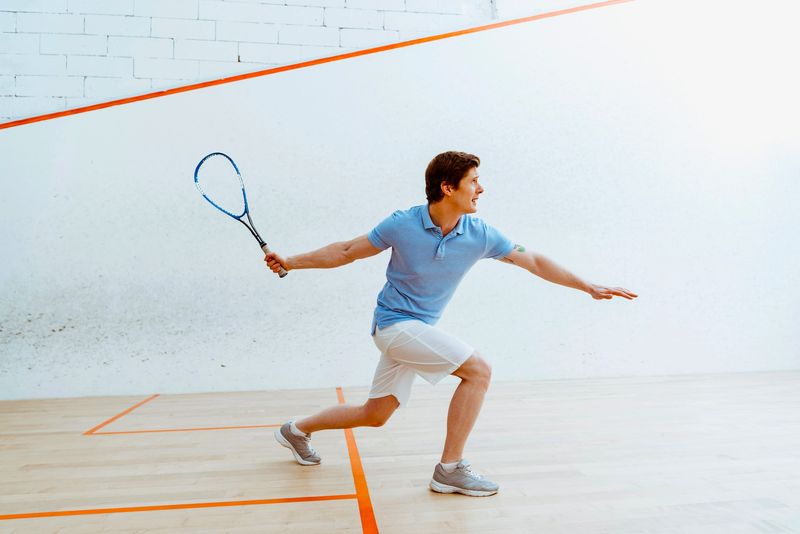 a man returning a squash ball with a heavy swing of his racket