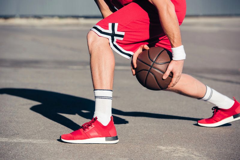 a basketball player passing a basketball through his legs