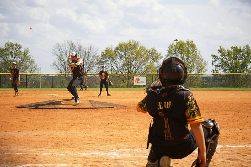 a youth baseball team practicing pitching and catching