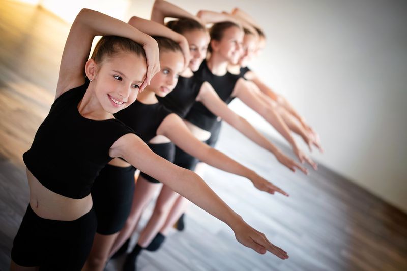 a group of young girl ballet dancers posing in front of each other in a line