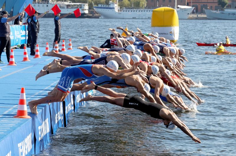 a group of mens swimmers diving into water