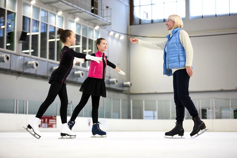 a figure skating instructor teaching two young girls