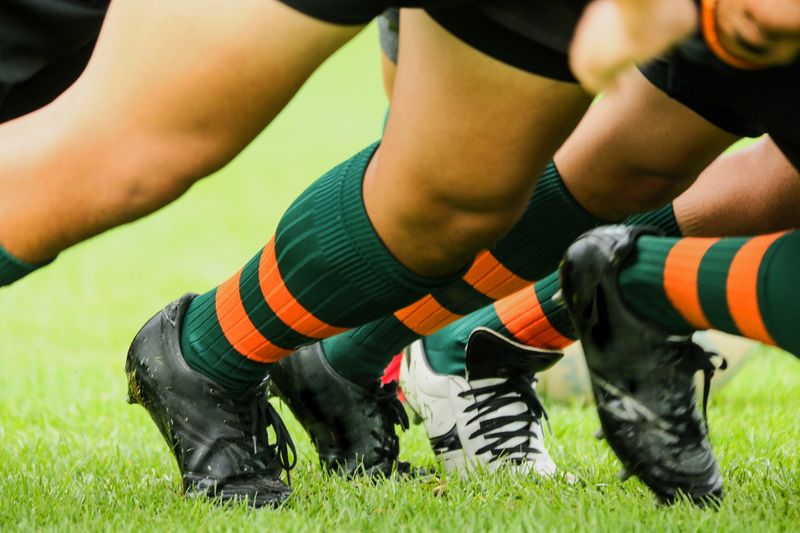 a close up of rugby players legs leaning forward