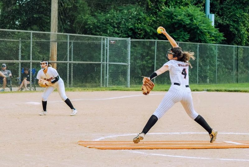 a female softball player pitching a softball