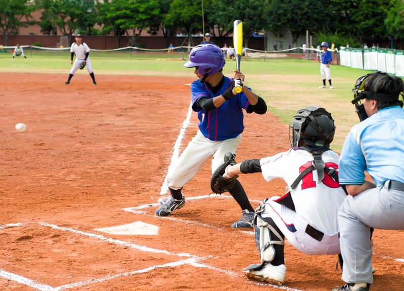 a youth baseball player about to swing on a pitch