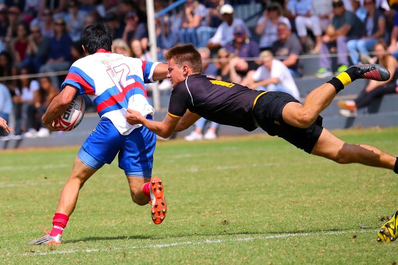 a rugby player tackling an opposing team rugby player