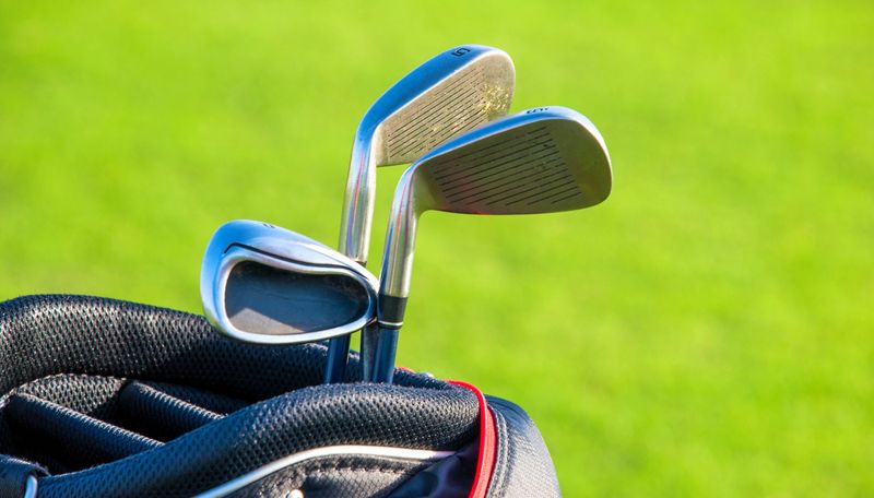 three golf irons in a golf bag