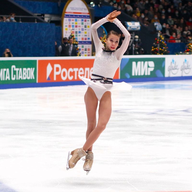 a youth female figure skating doing a spinning jump