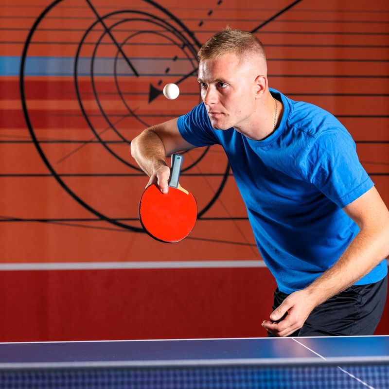 a male adult ping pong player using penhold grip on a paddle