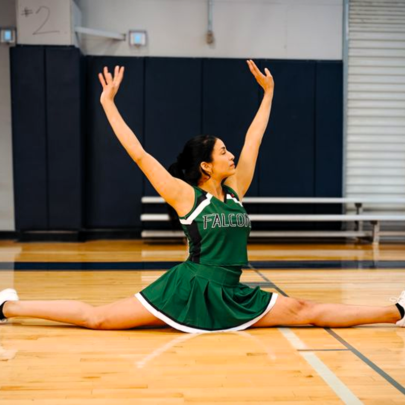 a female cheerleader doing the splits in cheer uniform