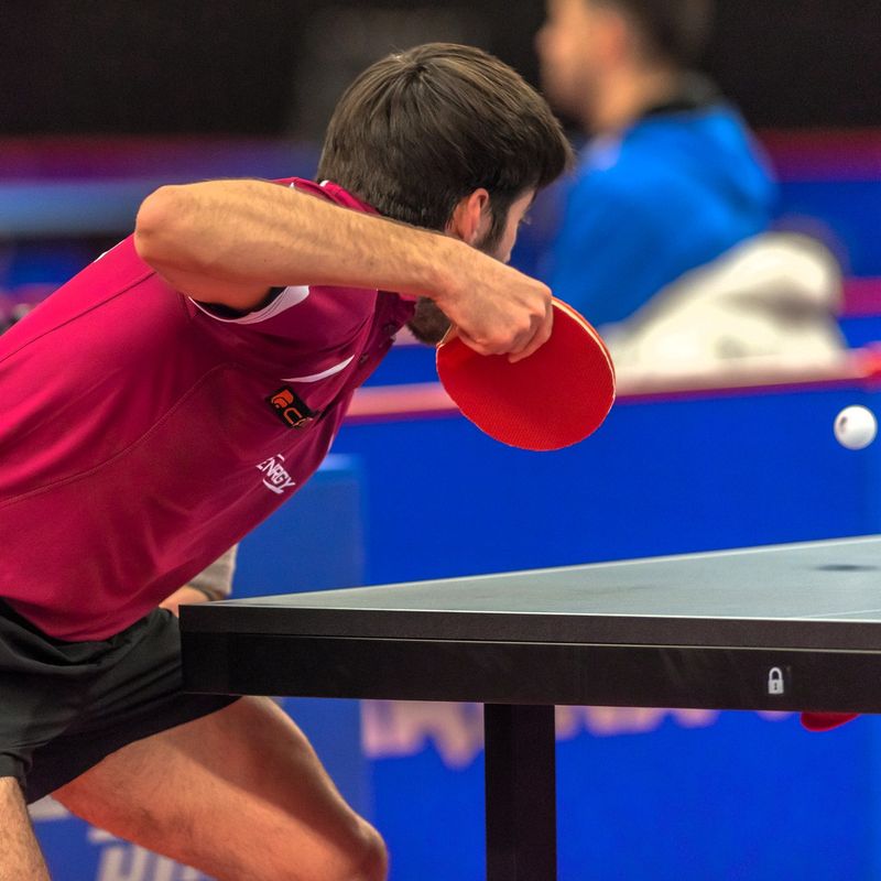 a ping pong player returning a ping pong ball