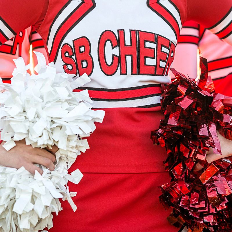 cheerleading wearing red cheer uniforms holding pom poms