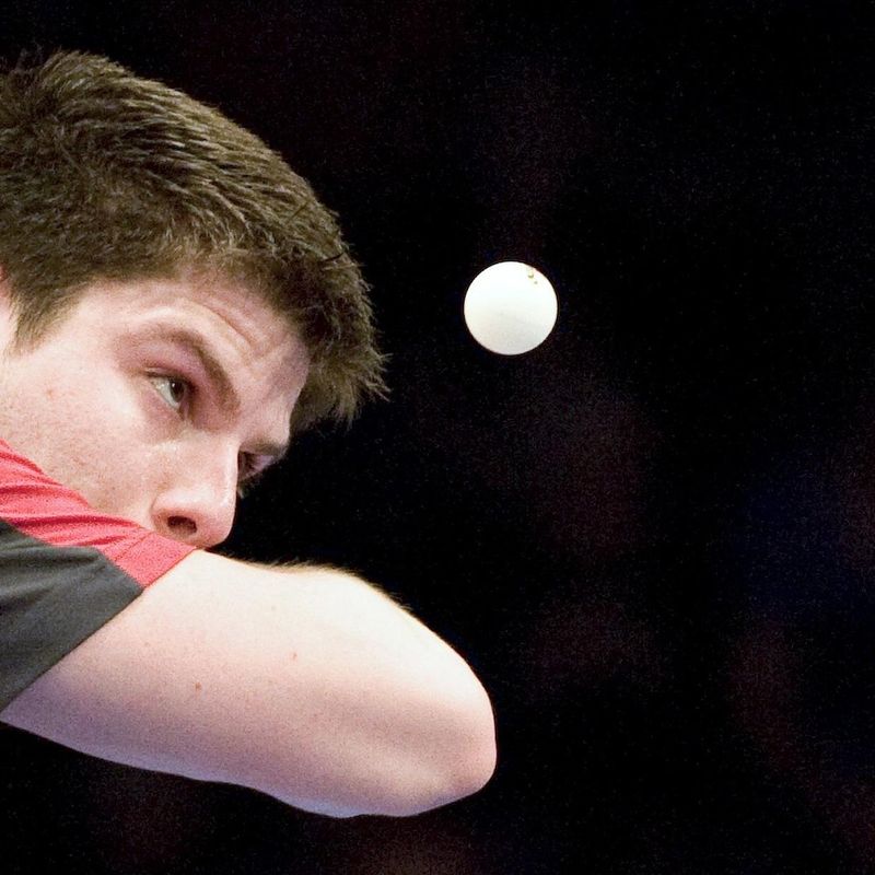 Ping pong player looking at ball in mid-air