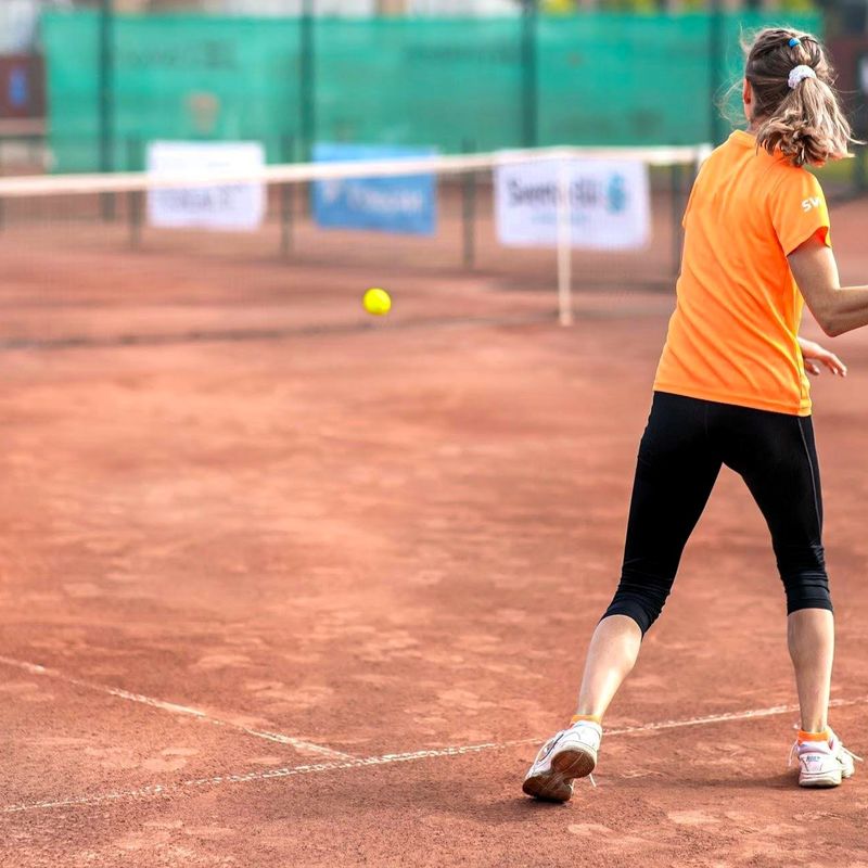 a female adult tennis player after striking a tennis ball