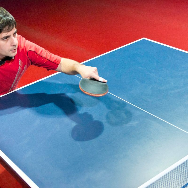 an adult ping pong player returning a serve
