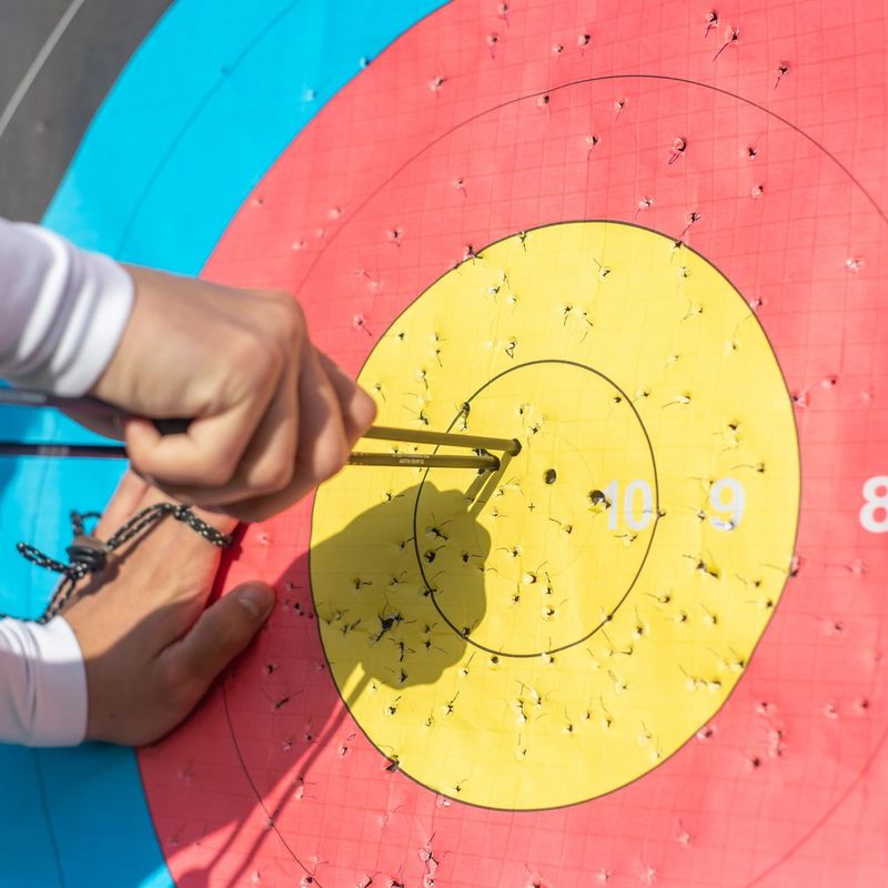 Person pulling arrows from target board