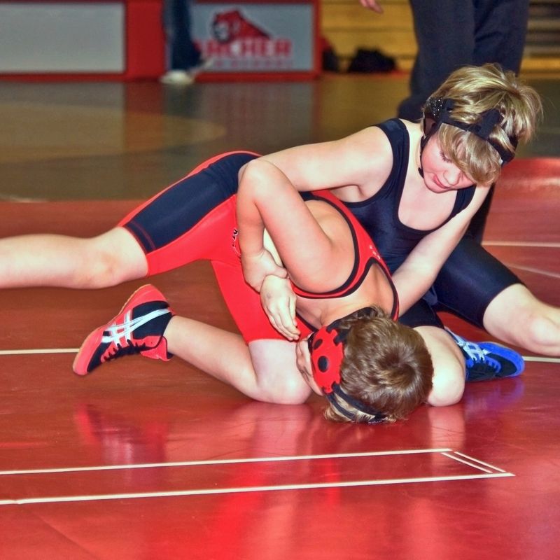 two youth wrestlers grappling on the ground