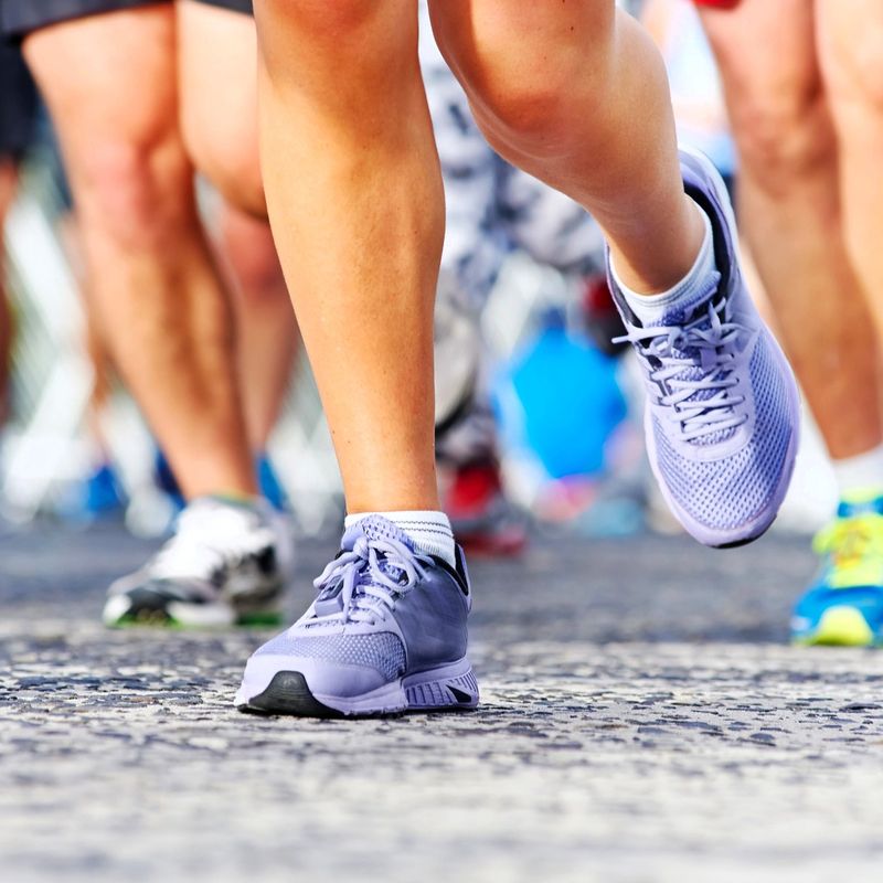 a group of runners wearing running shoes running on concrete