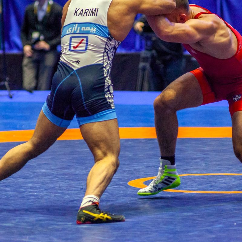 two professional wrestlers grappling while standing