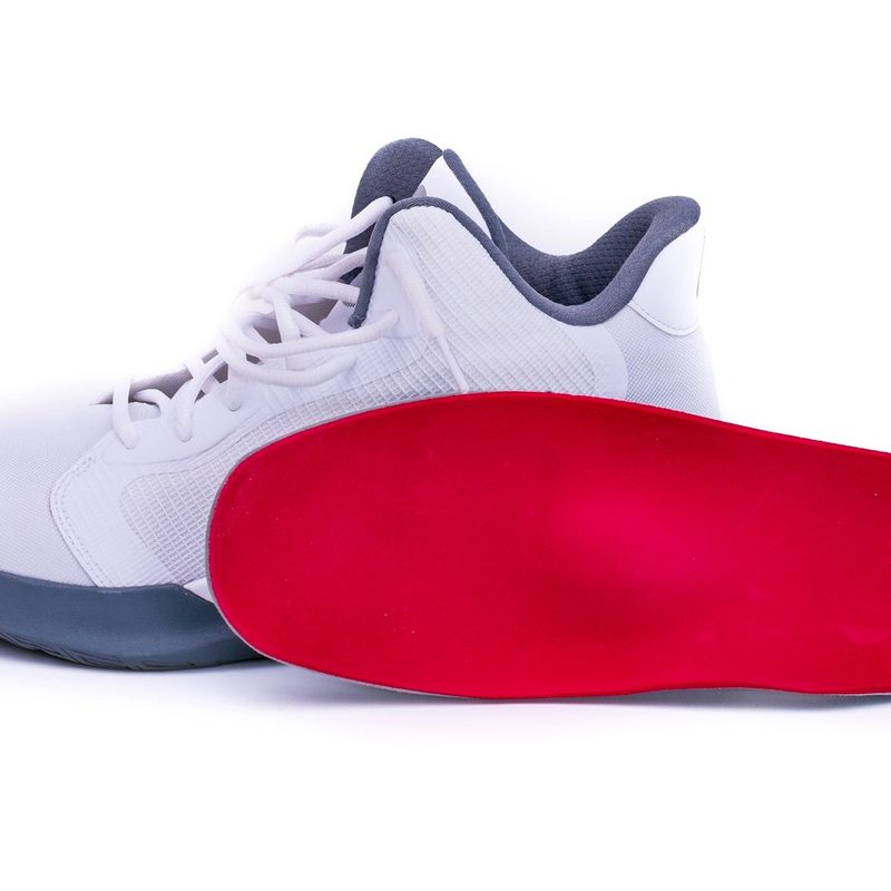 a white basketball shoe and a red shoe insert