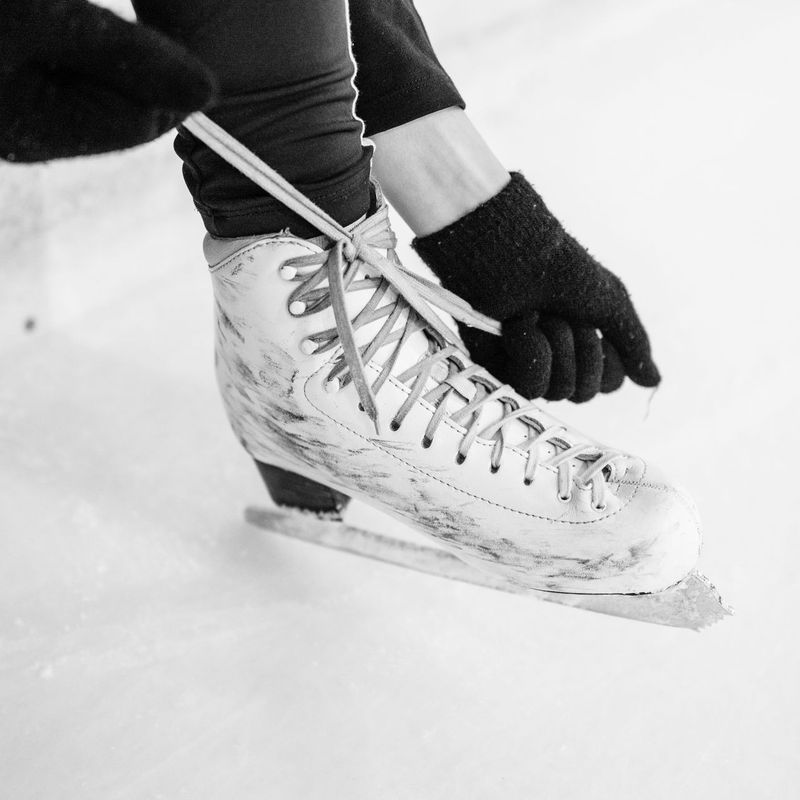 Person tying laces on ice skates