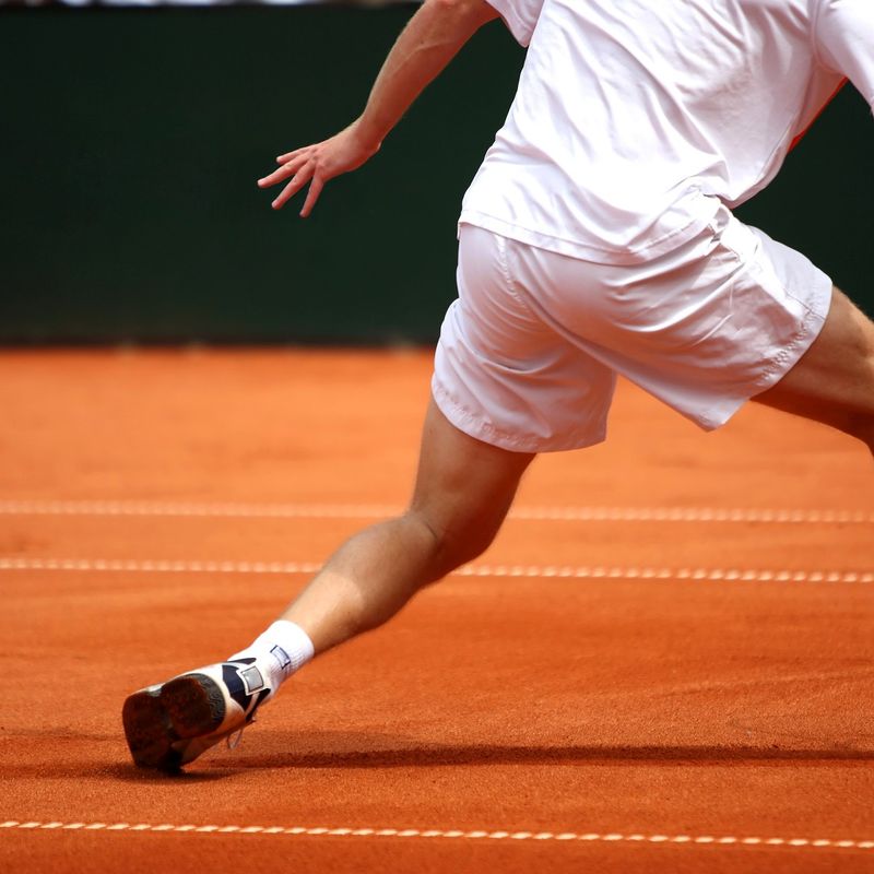 a male adult tennis player returning a serve