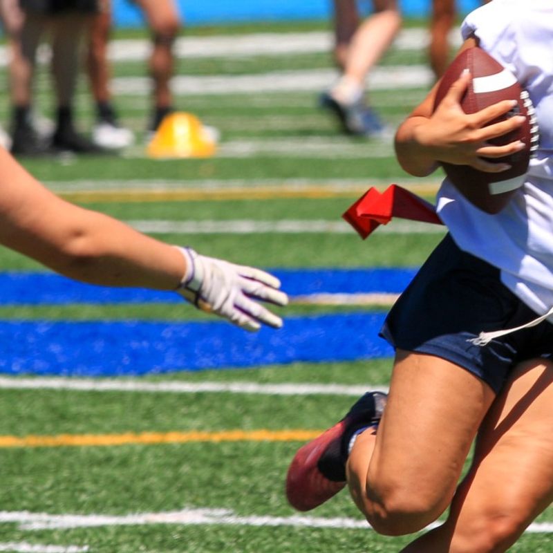 a flag football defender grabbing for an opponents flag