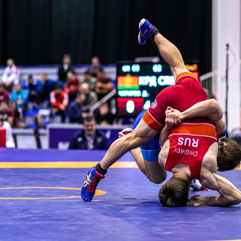 two professional wrestlers grappling in front of an audience